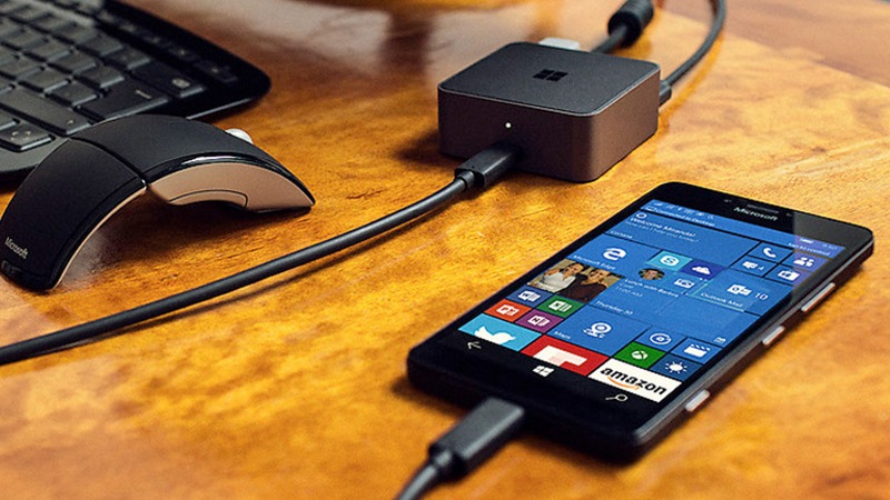 Lumia 950 plugged into a Microsoft Display dock with keyboard and mouse on desk 
