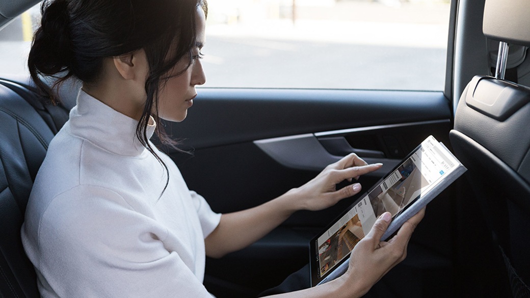 Woman in back of car on Surface Pro
