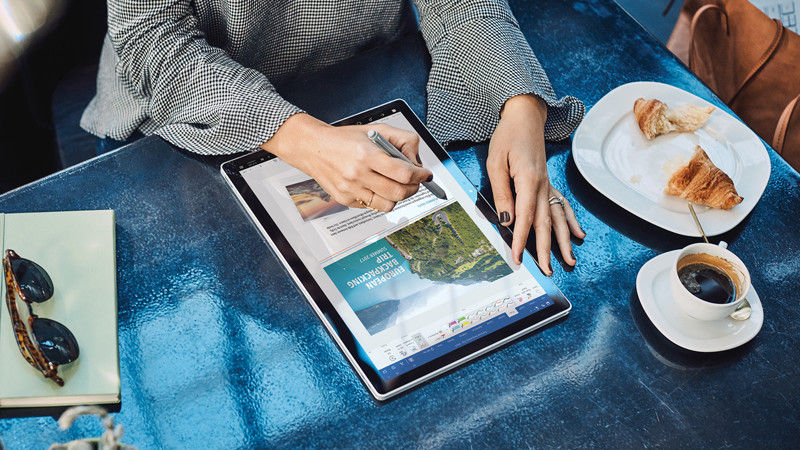 A female using the Surface Book at a cafe outdoor | Une femme utilisant un Surface Book dans un café en plein air