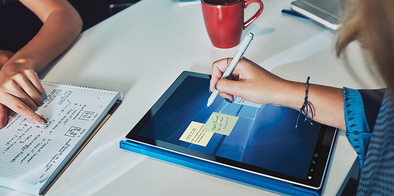 Person writing with Surface pen on a Surface Pro 4 in tablet mode with type cover folded back. | Personne qui écrit avec un stylet Surface sur une Surface Pro 4 en mode tablette avec clavier Type Cover déplié.