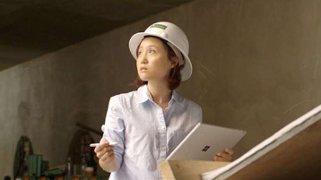 Architect Flora Lee wearing hard hat and holding Surface device