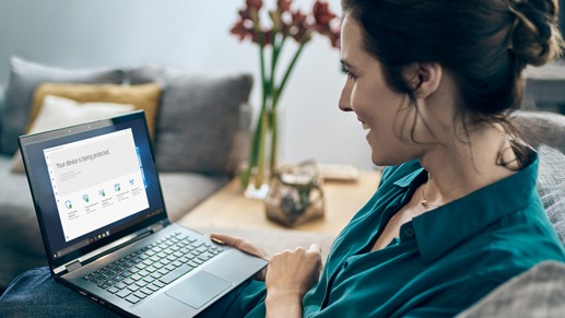 Yeni bir Windows 10 bilgisayar kullanarak masasında oturan bir kadın. 