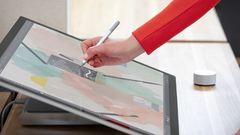 Person interacting with Surface Studio 2 and Surface Dial on screen