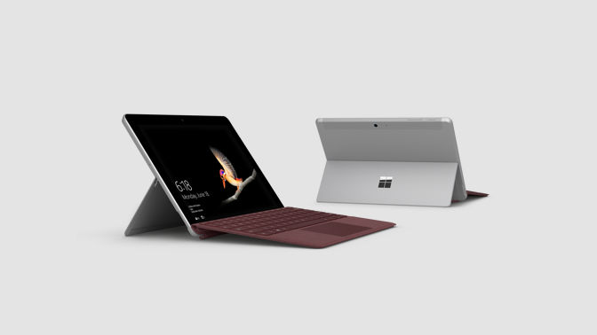 Two Surface Go devices with kickstand down on a flat surface