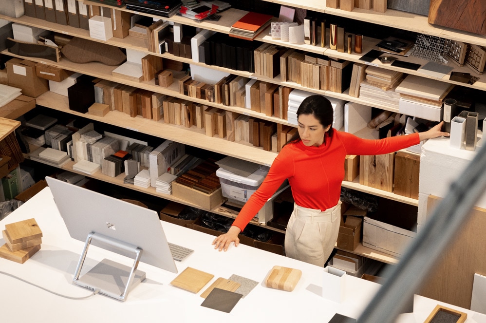 Uma mulher a trabalhar no Surface Studio 2 num ambiente de estúdio criativo