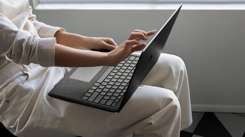 Person touching the Surface Laptop 2 screen