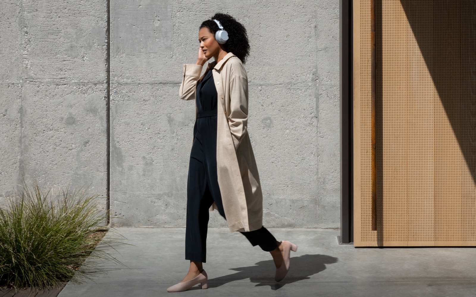 A woman walking with Surface Headphones on her head