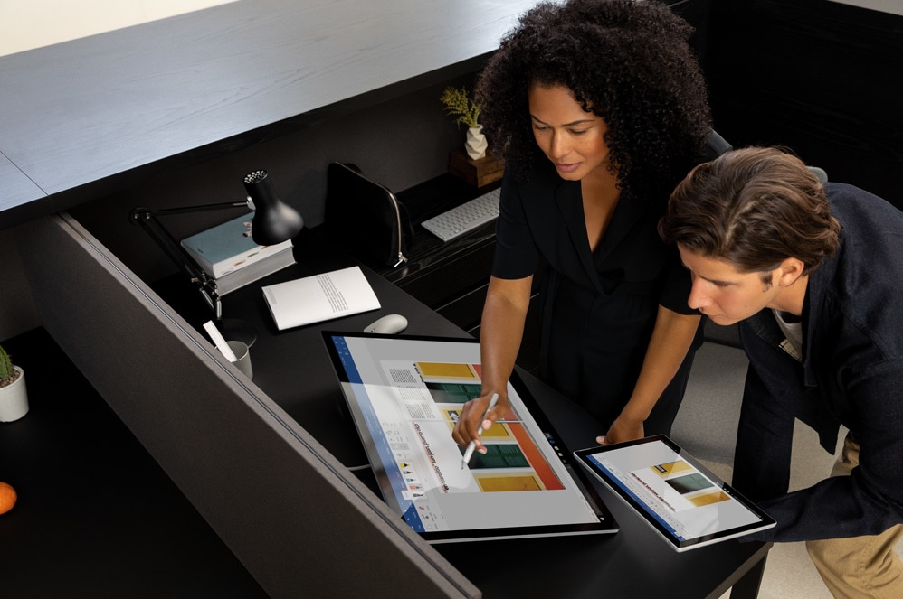 Two people interacting with the Surface Studio 2 computer