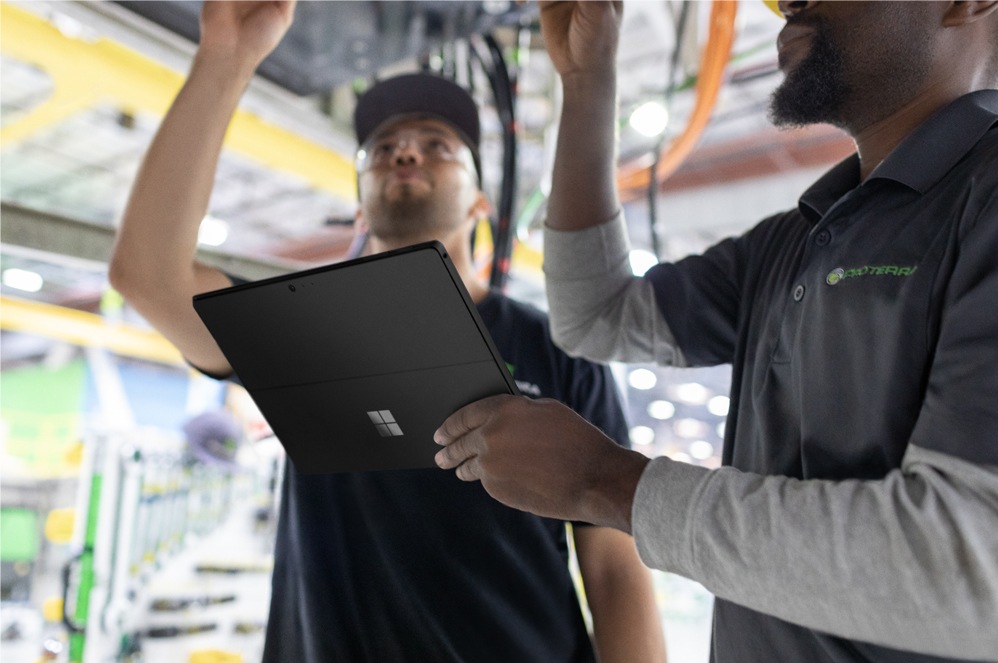 Two people collaborating while one types on the Surface Pro 6.