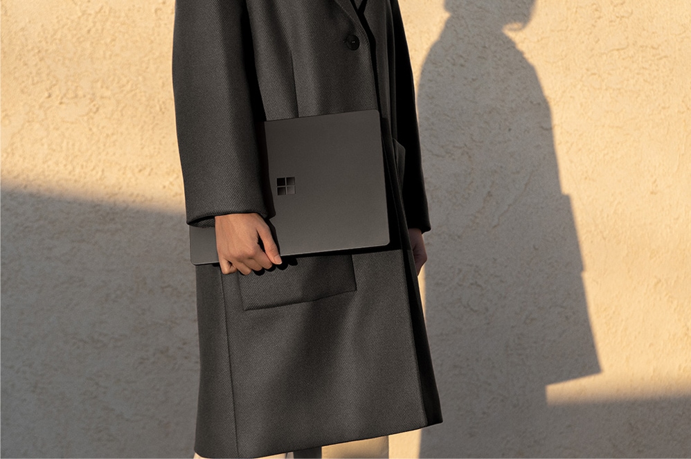 Person holding Black Surface Laptop 2