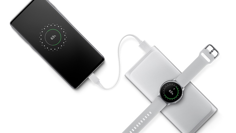 Samsung portable wireless charger in silver, charging a smart watch and a phone at the same time