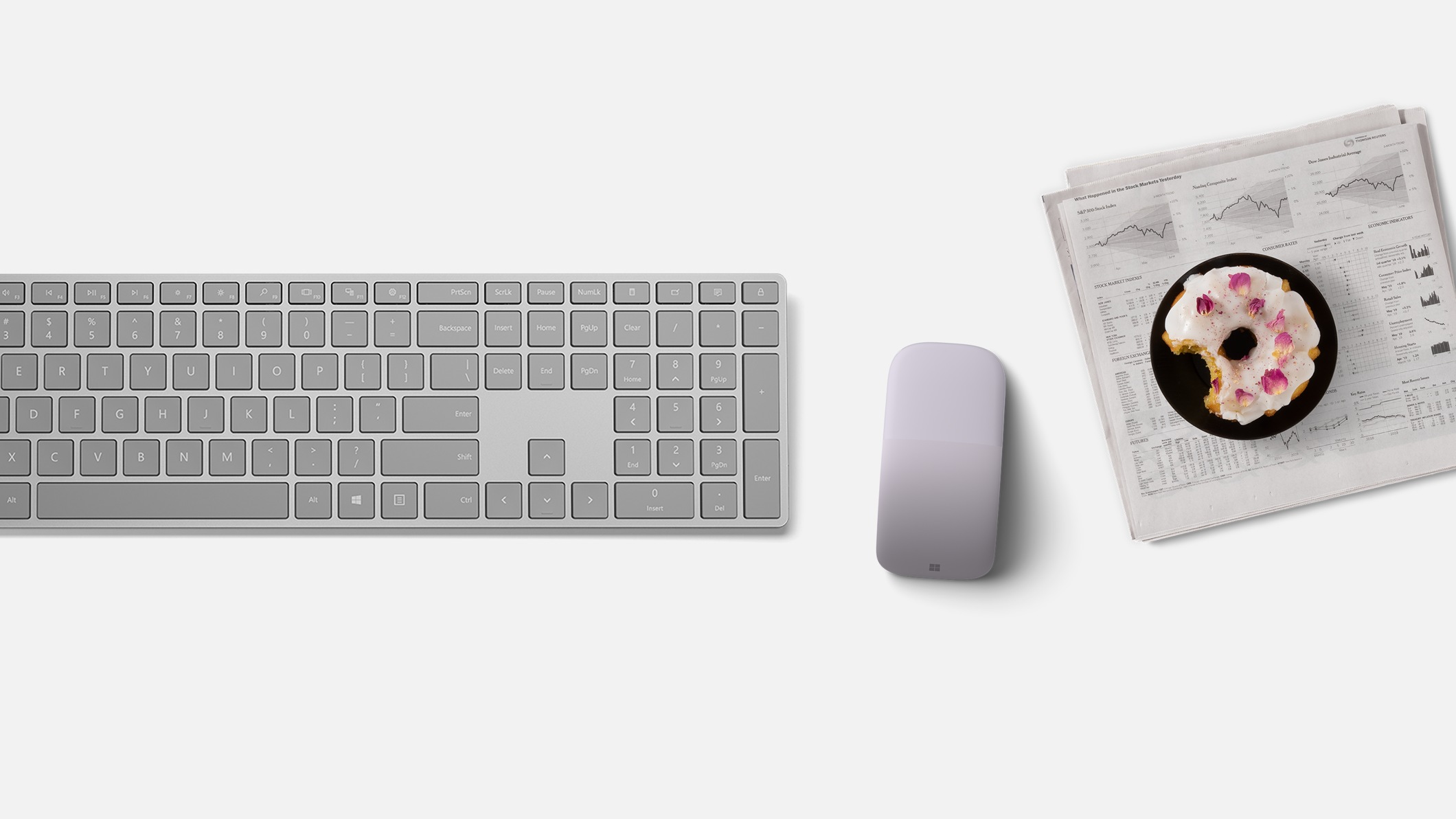 A Microsoft Arc Mouse sits next to a Surface Keyboard.