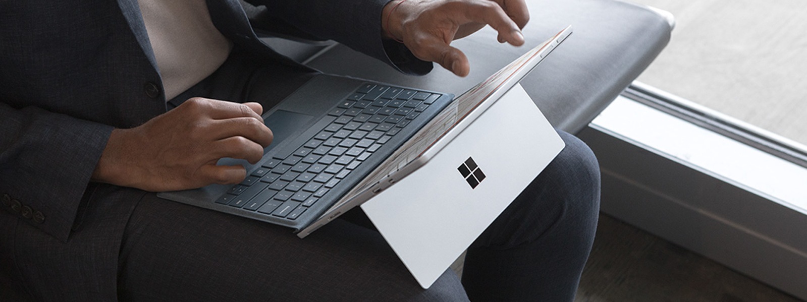 A Man Uses His Surface Pro And Surface Pro Signature Type Cover In Ice Blue