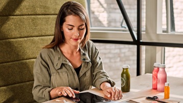 A person sitting alone using a tablet.