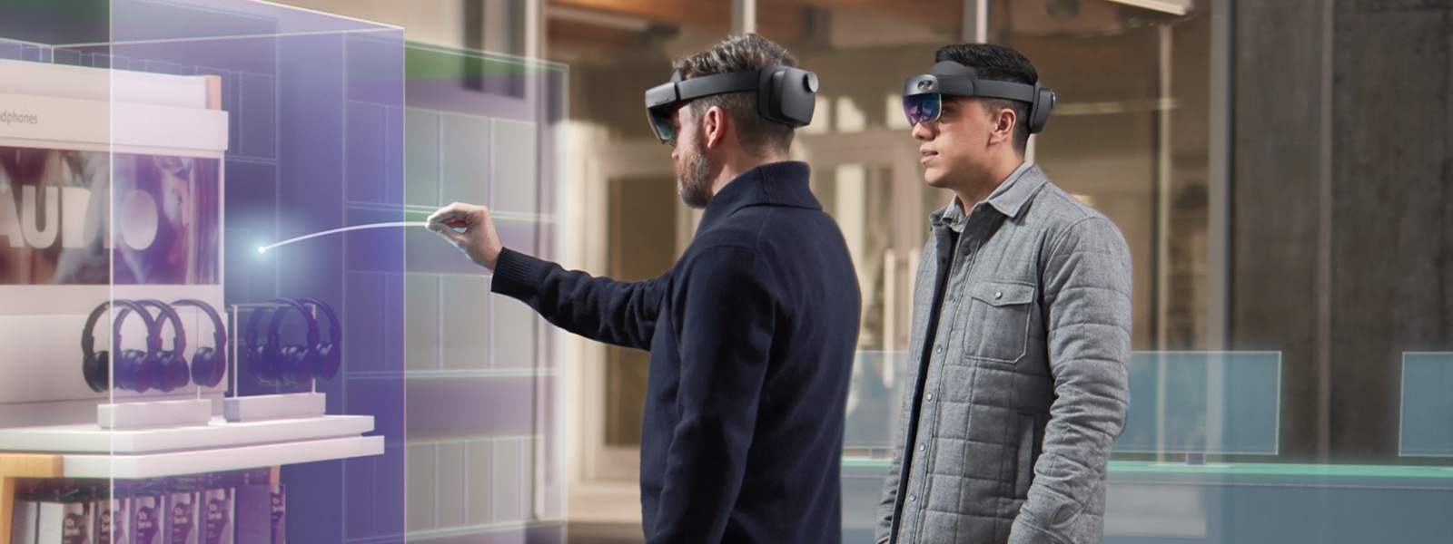 A man uses a HoloLens device to interact with an inventory item, while his coworker looks on.