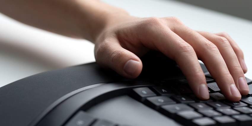 A person types on the Microsoft Ergonomic Keyboard