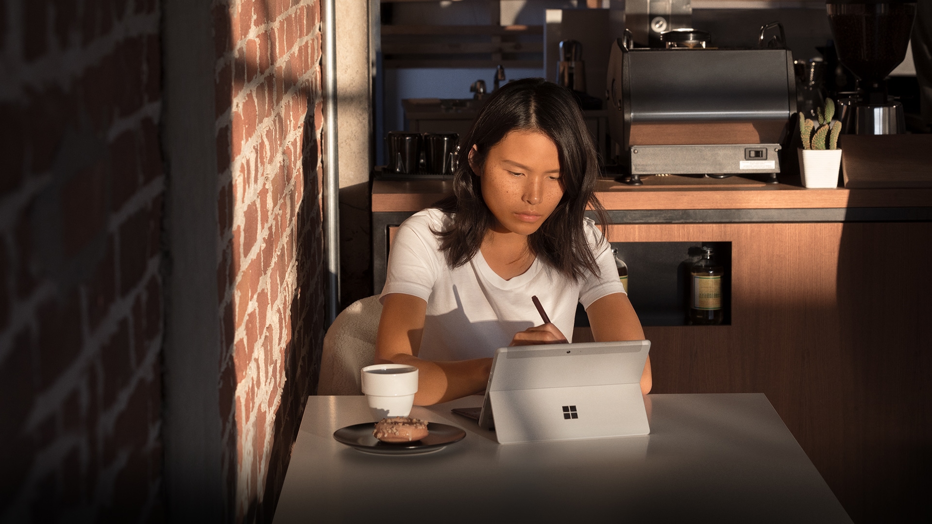Young woman working on a Surface Go in a coffee shop