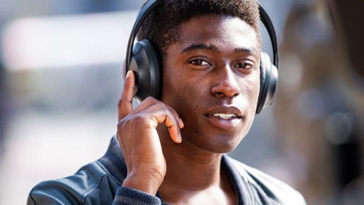 Lifestyle image of a black man using the Bose NC Headphones 700 Black