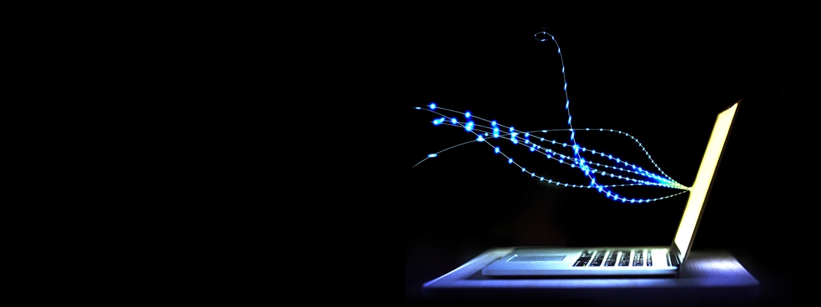 Ein Laptop mit einer Darstellung von Lichtstrahlen, die vom Bildschirm ausgehen.