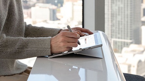 Une femme écrit sur une Surface Pro 7 à l'aide d'un stylet Surface