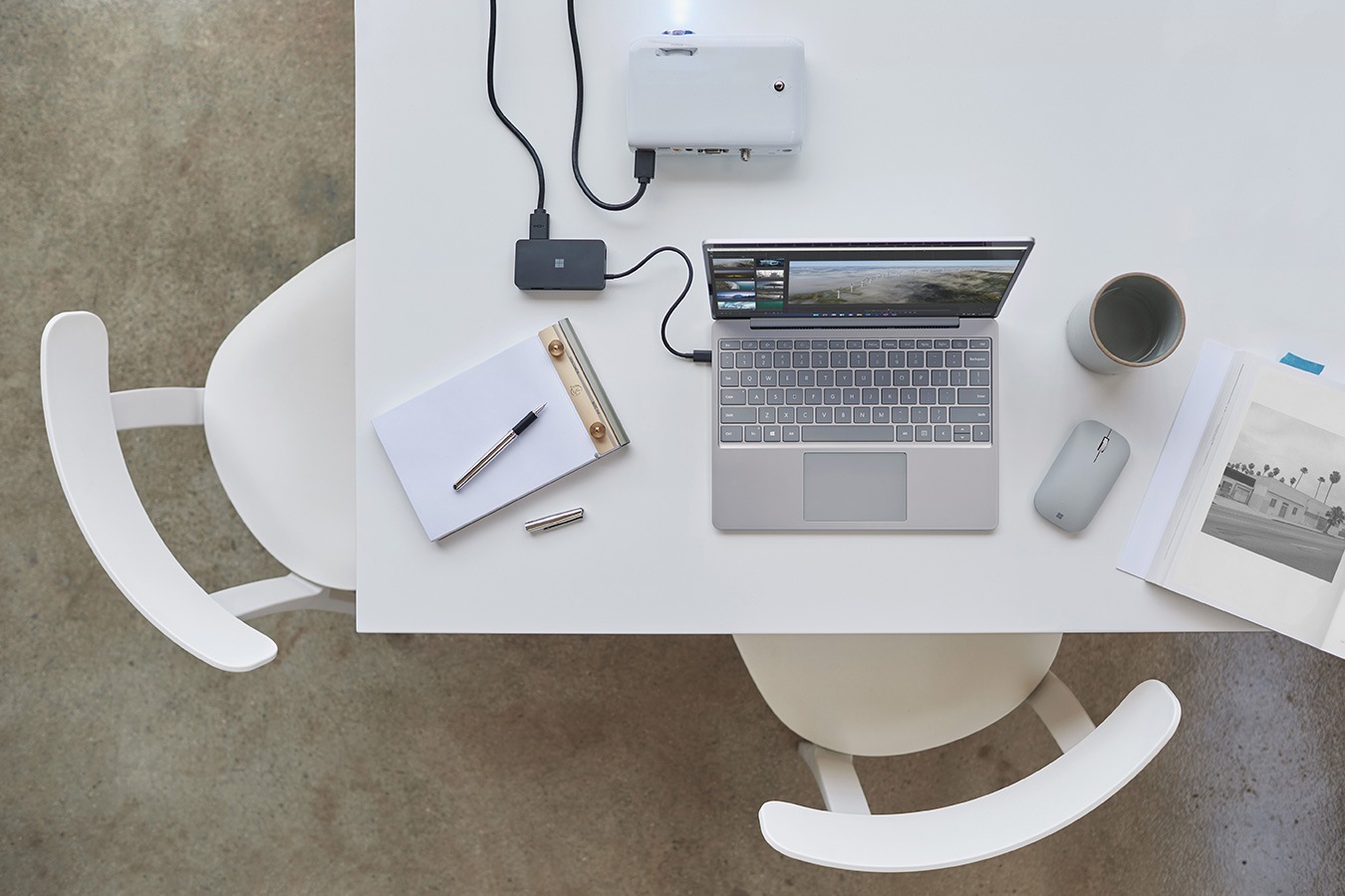 Surface Laptop Go på ett skrivbord och ansluten till en projektor