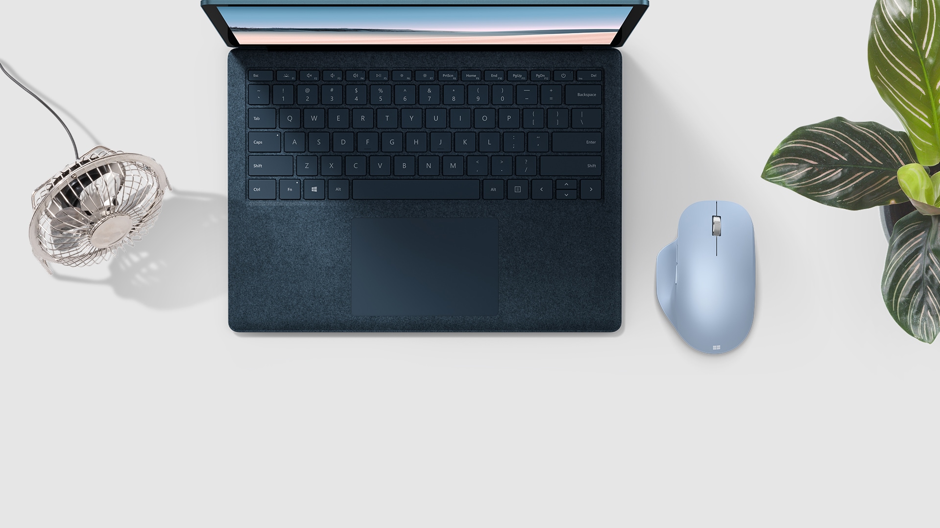 Souris Microsoft Bluetooth® Ergonomic Mouse à côté d’un clavier.