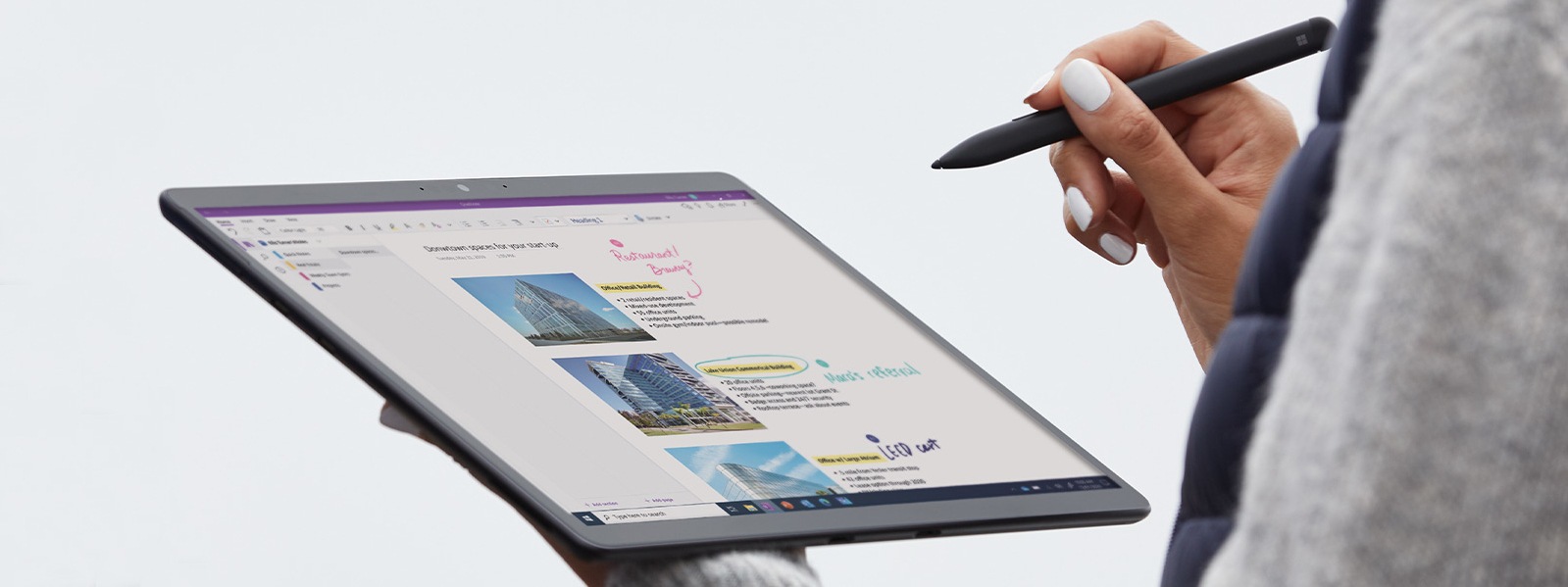 Eine Person hält einen Surface Pro X in einer Hand und Surface Slim Pen in der anderen