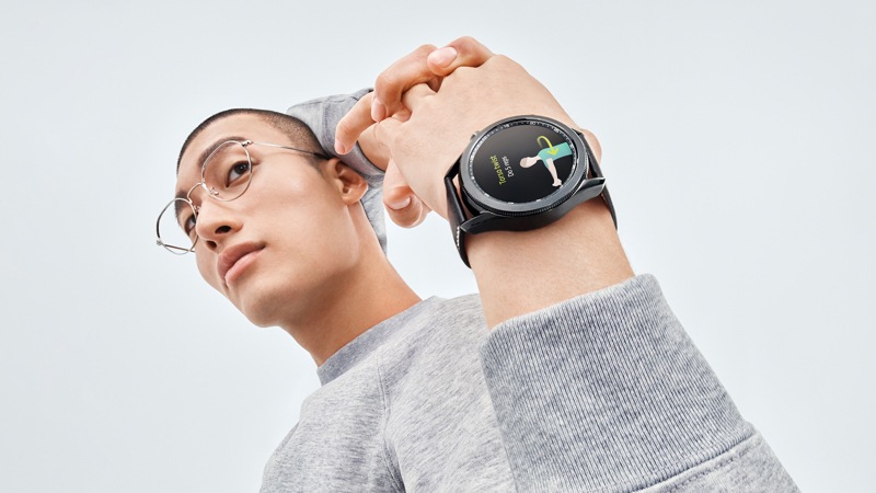 Man using a Samsung Galaxy Watch 3 fitness app to stretch.