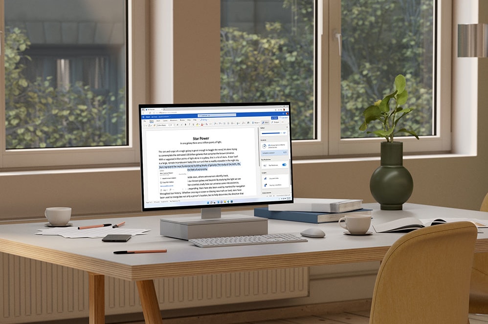 Un tablet che visualizza Microsoft PowerPoint appoggiato accanto a una macchina fotografica, a una tazza di caffè e a dei rotoli di carta.
