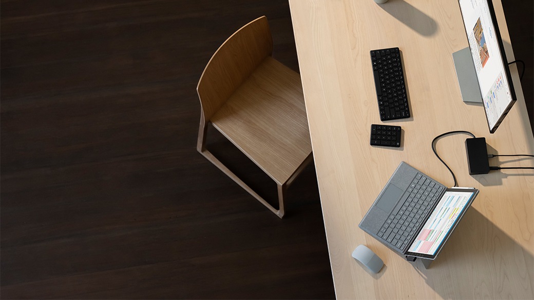 책상 위에서 Surface Dock 2를 통해 여러 주변 기기와 모니터에 연결된 Surface Pro 7
