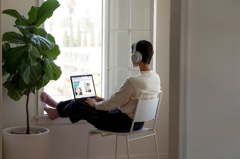 Osoba pisząca na komputerze Surface Laptop 3 i jednocześnie pracująca nad prezentacją