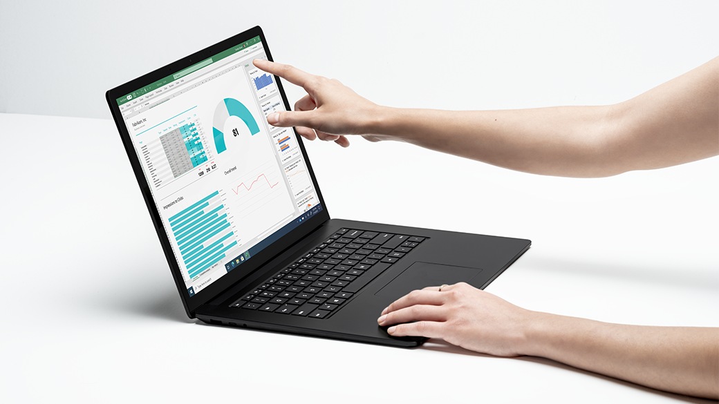 A person’s hands working with Surface Laptop 4, one on the keyboard, the other touching the screen. 