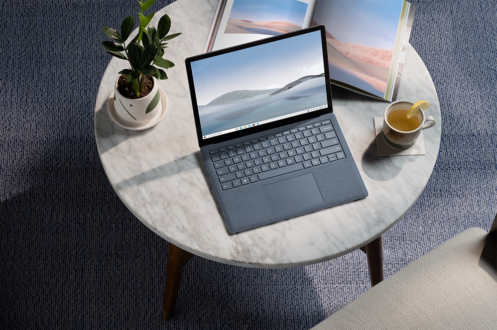 Person sitzt an einem Schreibtisch und arbeitet mit Surface Laptop 4 for Business.