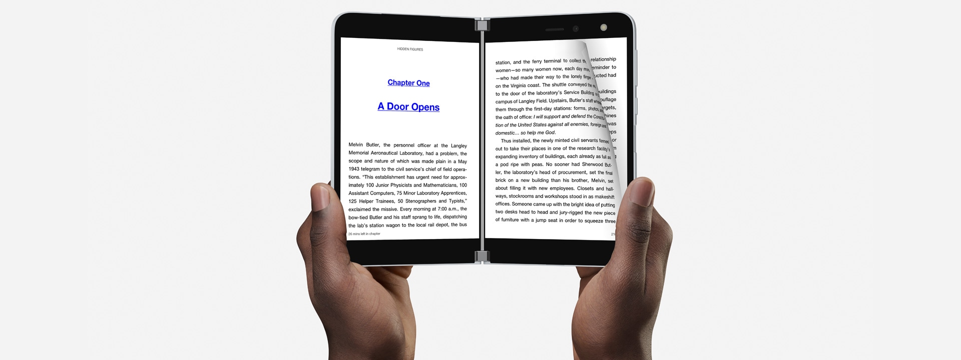 A person's hands holding the Surface Duo to read a book.