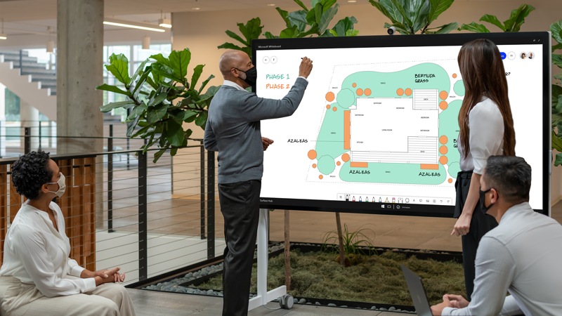 Eine Person verwendet das Surface HUB 2S in 85 Zoll auf der mobilen Halterung in einer Büroumgebung.
