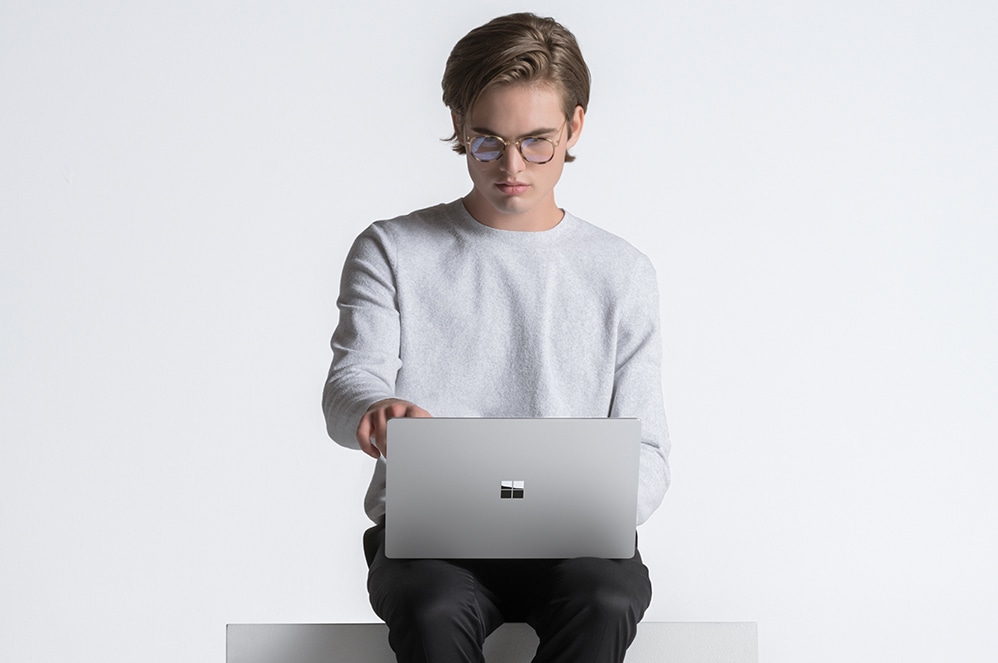 무릎에 Surface Laptop 4을(를) 올려놓고 앉아 있는 남성