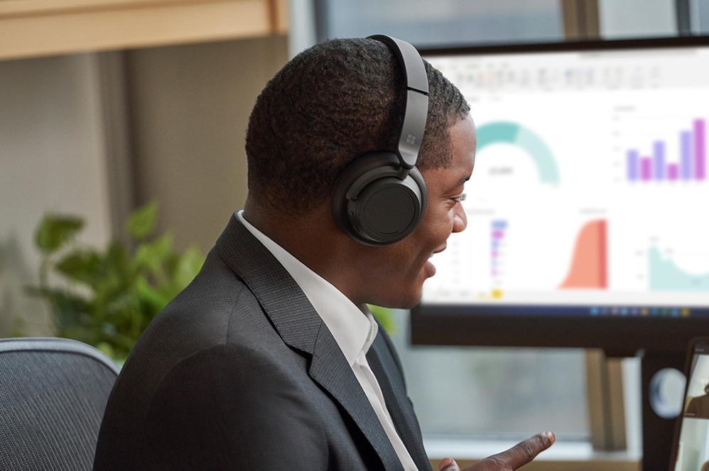 Osoba w słuchawkach Surface Headphones 2+ podczas połączenia w usłudze Microsoft Teams