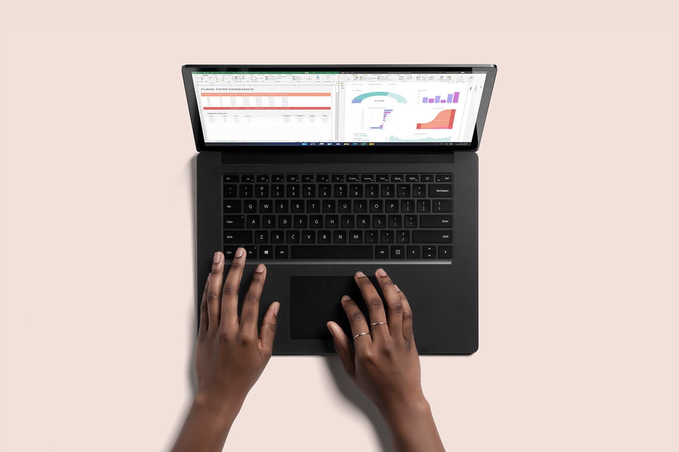 Bovenaanzicht van de zwarte Surface Laptop 4, met twee handen die typen op het toetsenbord
