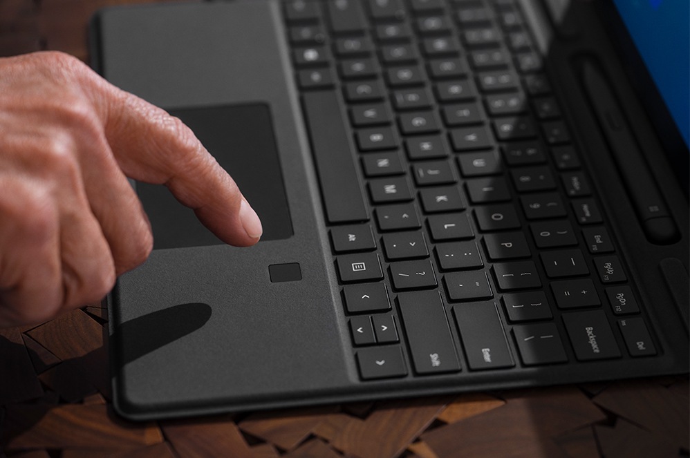 A person’s finger interacting with Surface Pro Signature Keyboard with Fingerprint Reader.