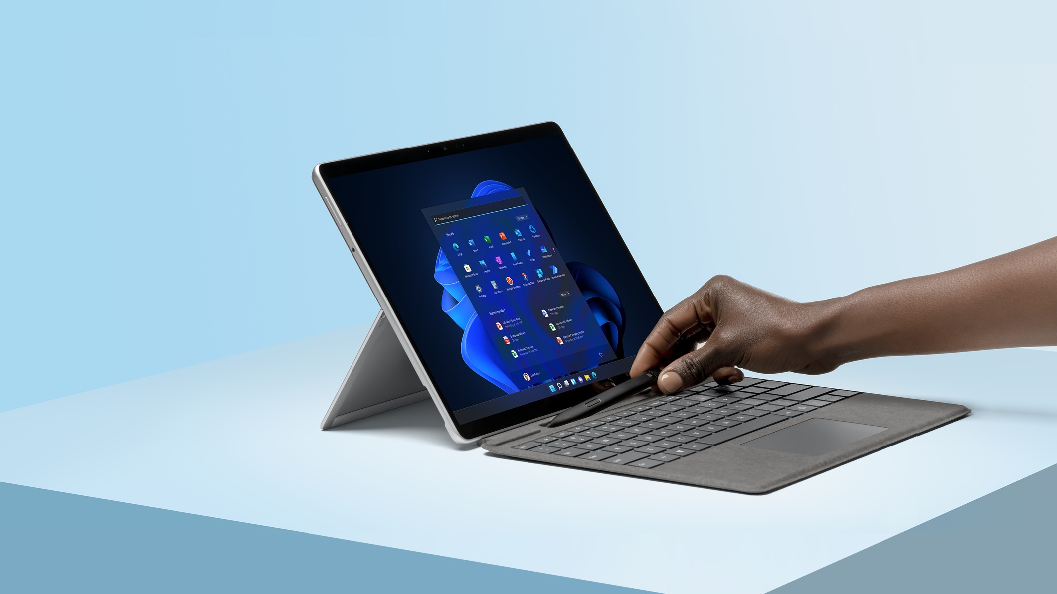A person’s hand removing Surface Slim Pen 2 from Surface Pro Signature Keyboard attached to a Surface Pro device.