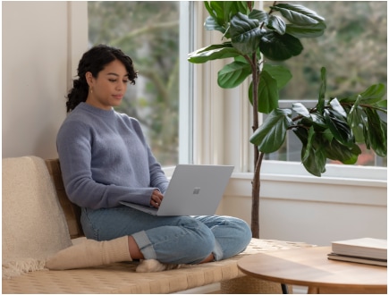 A person lounging on a couch using a laptop. 