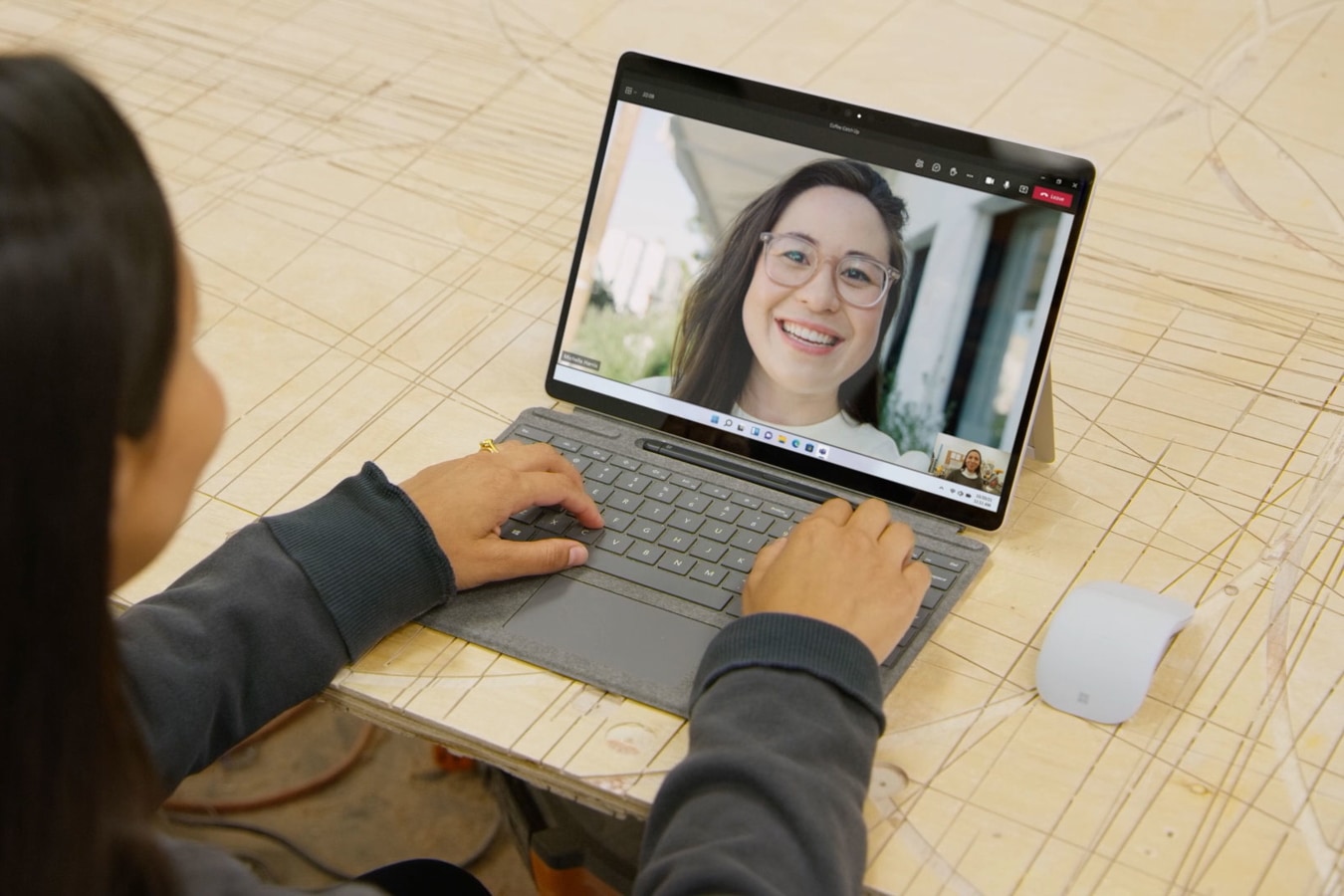 A person catching up with a friend on Surface Pro X.