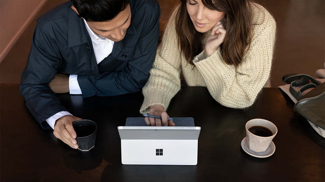 Vue de dessus de la Surface Go 3 pour les entreprises sur un bureau avec un clavier Type Cover associé, ainsi qu’une souris et des écouteurs.