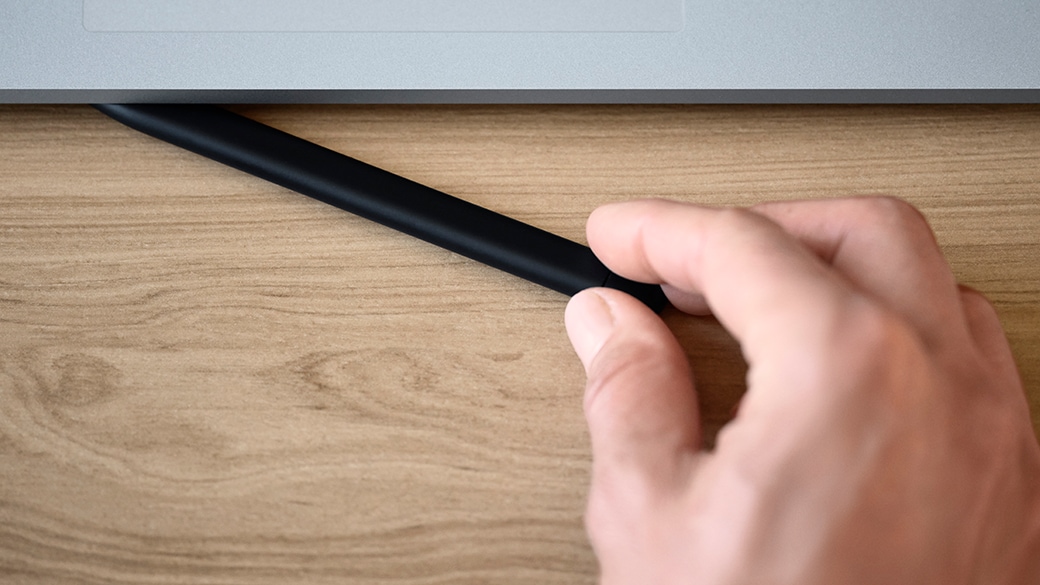 Draufsicht eines Schreibtischs mit Surface Laptop Studio for Business, Tastatur und Monitor.