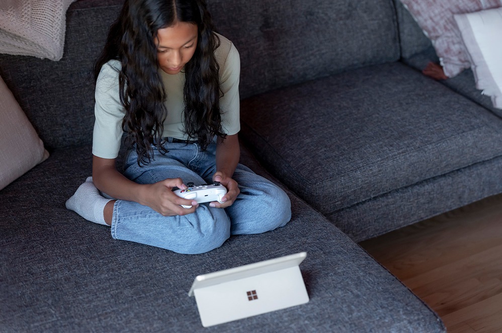 A child gaming on Surface Go 3 in kickstand mode.