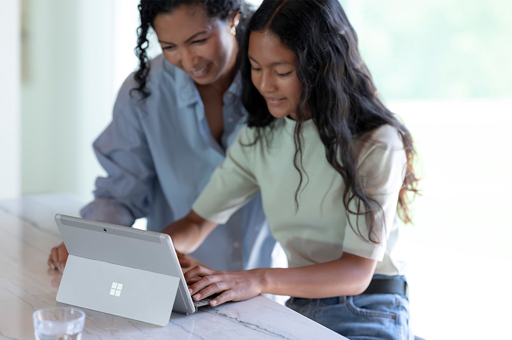En förälder och ett barn använder Surface Go 3 tillsammans.