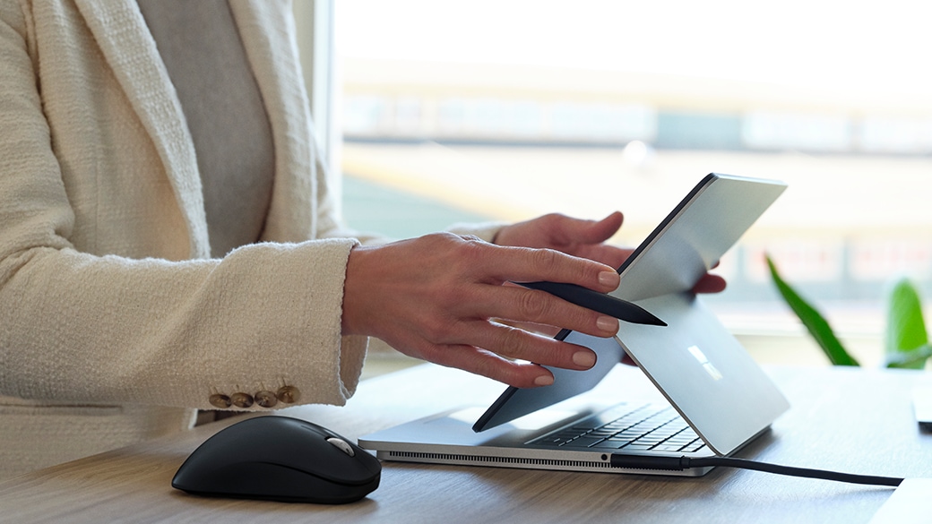 A person’s hand interacting with Surface Laptop Studio for Business.