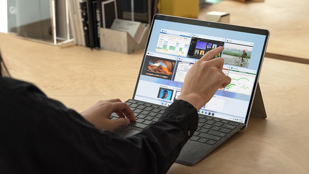 Person tapping the screen of Surface Pro X.