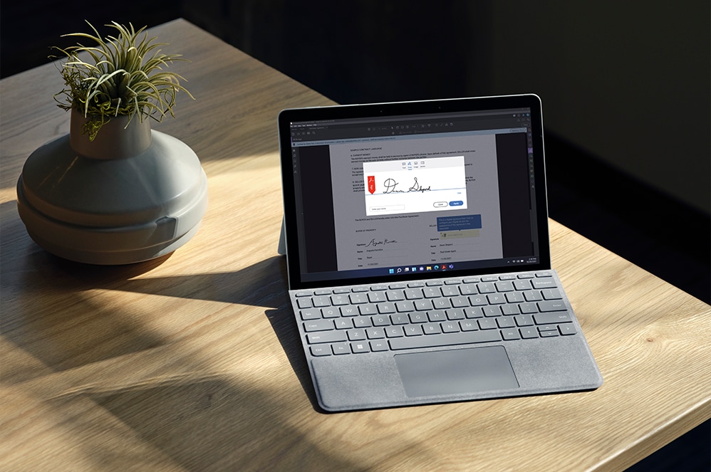 Surface Go 3 for Business mit angebrachtem Type Cover auf einem Schreibtisch.
