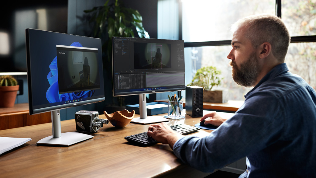 Un hombre sentado en un escritorio usa una estación de trabajo Windows 11 Pro.